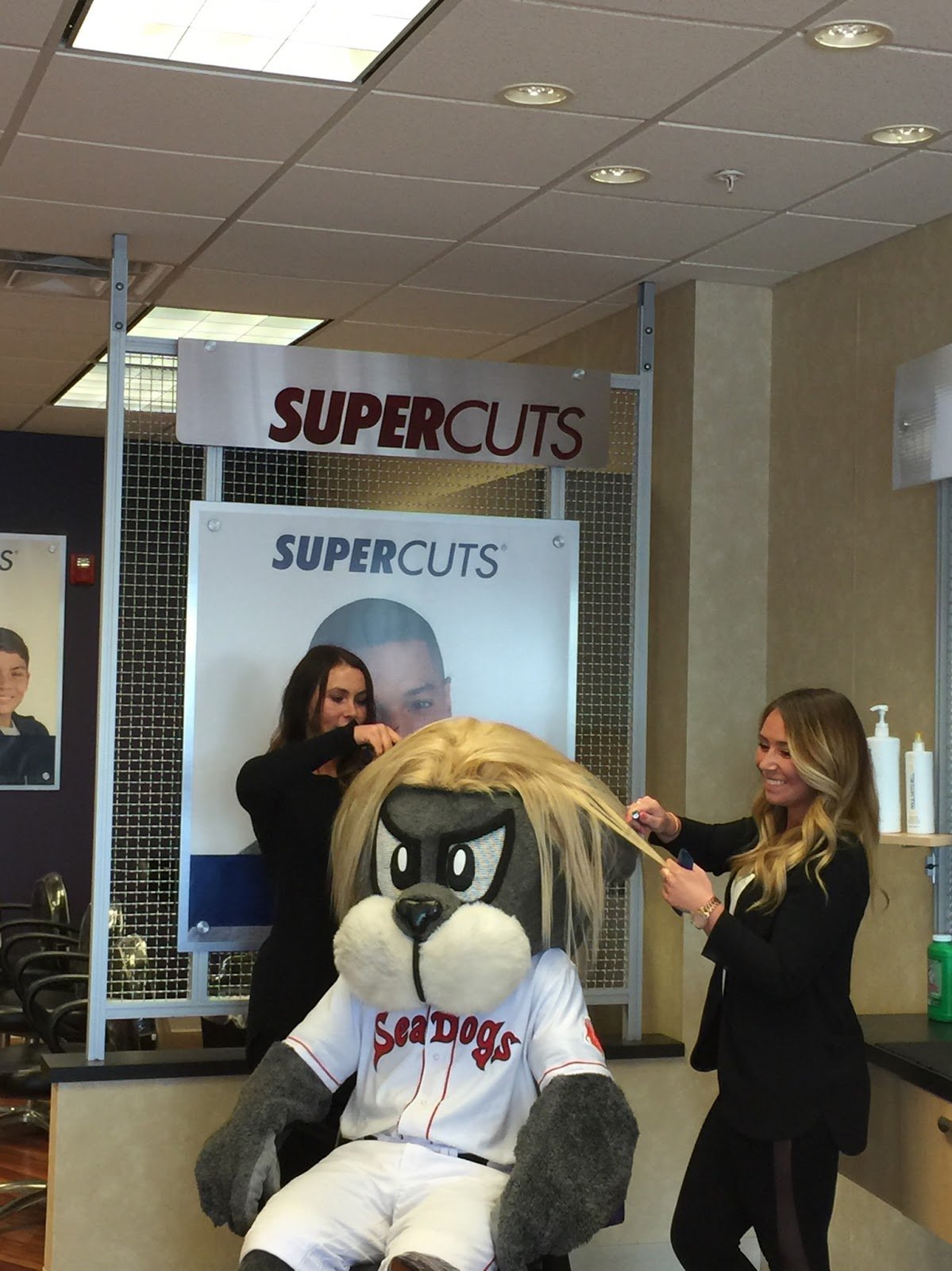 Slugger, the Portland Sea Dogs mascot, visiting a Supercuts salon